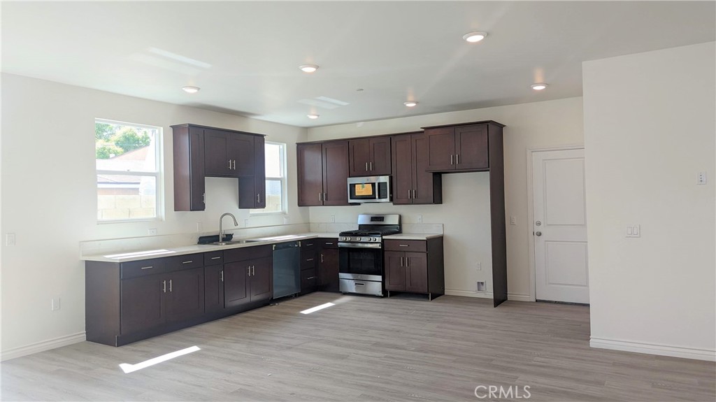 15115 Logos Court North Hills, CA 91343 - Photo 6 of 21 a large kitchen with stainless steel appliances granite countertop a stove a sink and a refrigerator