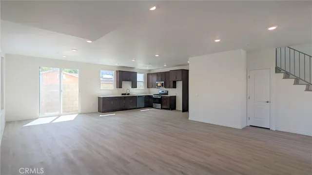 a large kitchen with stainless steel appliances granite countertop a large counter top and a wooden floor