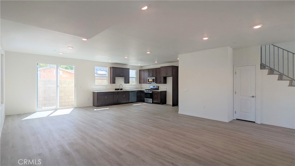 15115 Logos Court North Hills, CA 91343 - Photo 7 of 21 a large kitchen with stainless steel appliances granite countertop a large counter top and a wooden floor
