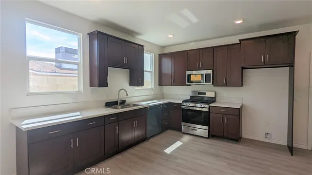 a kitchen with granite countertop stainless steel appliances cabinets a sink and a window