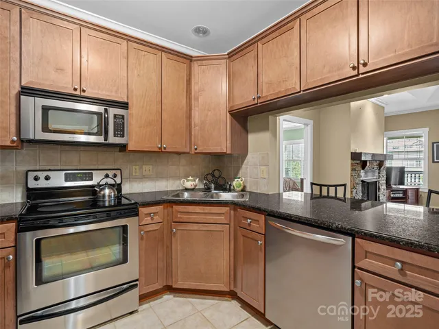 a kitchen with stainless steel appliances granite countertop a sink stove microwave and cabinets
