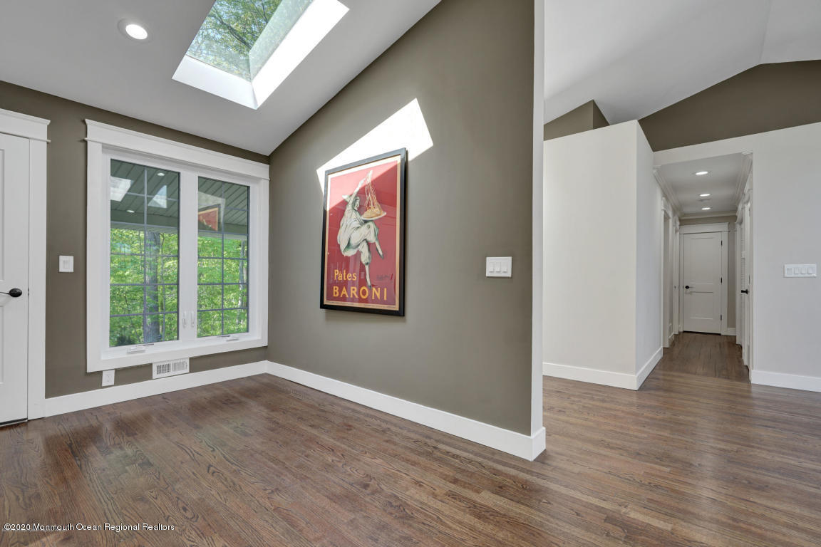 236 Holland Road Holmdel, NJ 07733 - Photo 19 of 42 a view of an empty room with wooden floor and a window