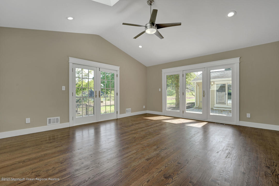 236 Holland Road Holmdel, NJ 07733 - Photo 21 of 42 a view of an empty room with wooden floor and a window