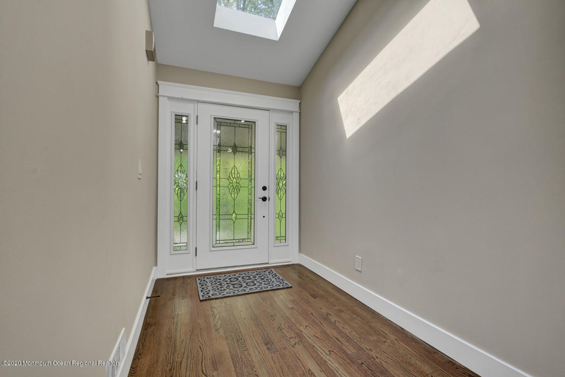 236 Holland Road Holmdel, NJ 07733 - Photo 37 of 42 a view of an empty room with wooden floor and a window
