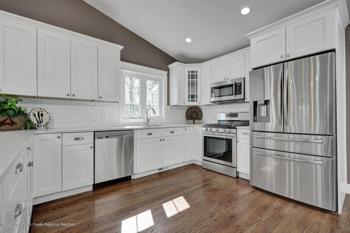 236 Holland Road Holmdel, NJ 07733 - Photo 5 of 42 a kitchen with granite countertop white cabinets stainless steel appliances and wooden floor