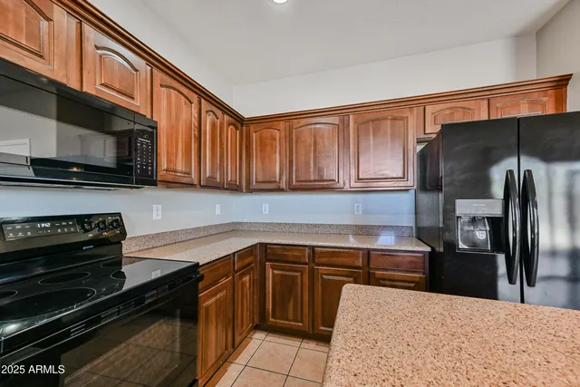 a kitchen with stainless steel appliances granite countertop a refrigerator and a stove top oven