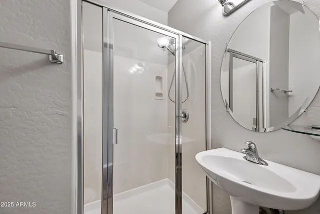 a bathroom with a sink mirror and shower