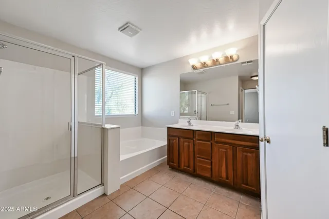 a spacious bathroom with a tub sink and mirror