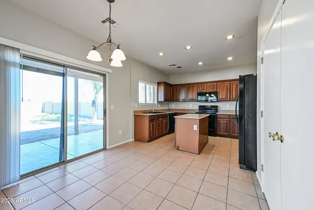 a kitchen with stainless steel appliances granite countertop a refrigerator a sink and a stove