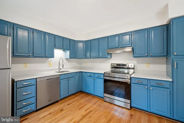 a kitchen with granite countertop wood cabinets stainless steel appliances and a sink