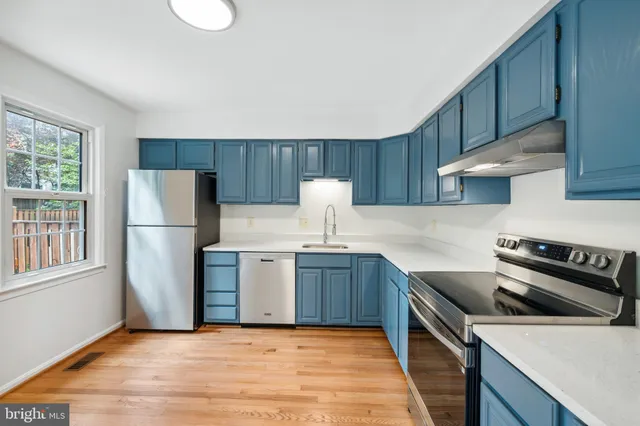 a kitchen with a sink a stove a refrigerator and cabinets
