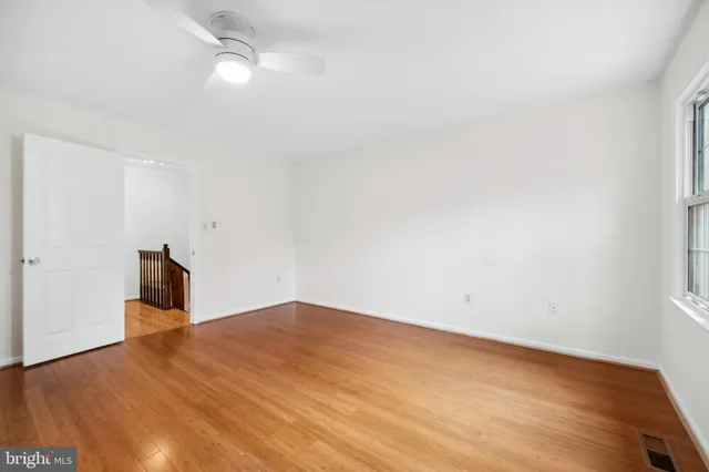 a view of empty room with wooden floor