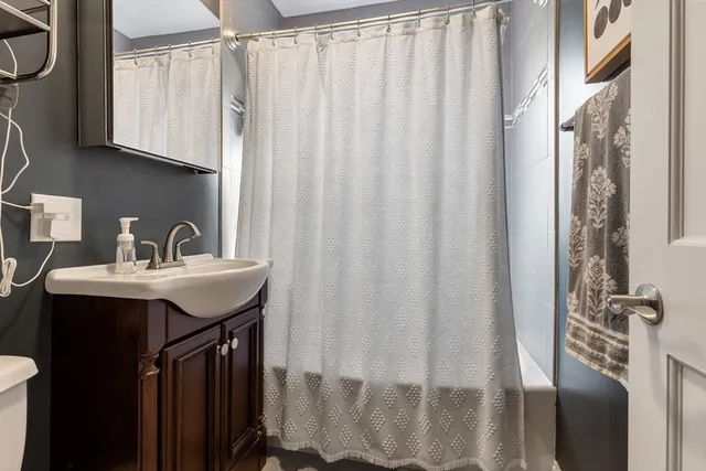 a bathroom with a sink a mirror and a shower curtain