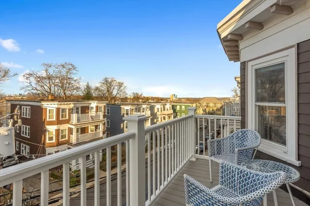 a view of a balcony with wooden chairs