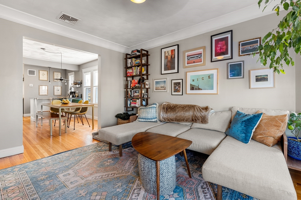 24 Thelma Road, Unit PH Boston, MA 02122 - Photo 2 of 17 a living room with furniture and a dining table with wooden floor