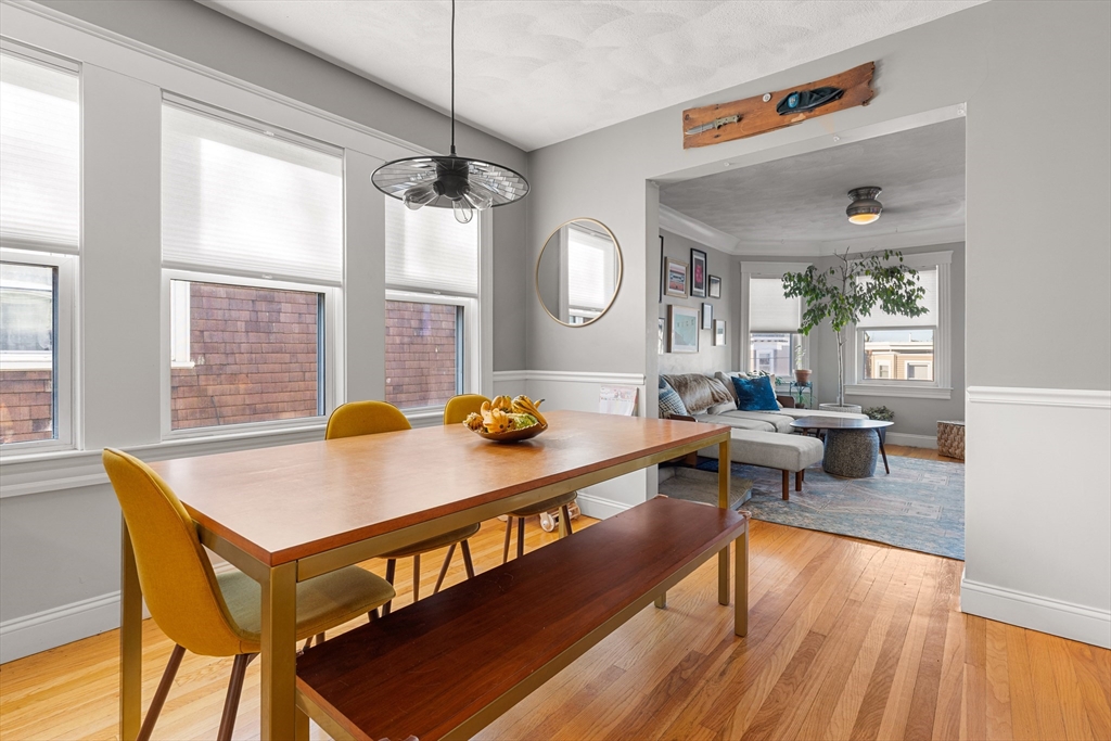 24 Thelma Road, Unit PH Boston, MA 02122 - Photo 3 of 17 a living room with a table chairs and wooden floor