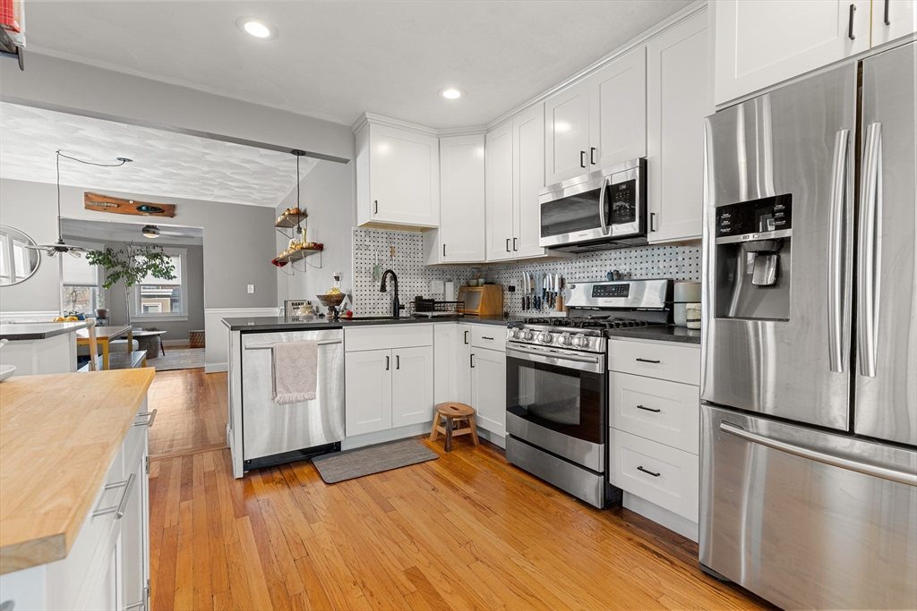 24 Thelma Road, Unit PH Boston, MA 02122 - Photo 5 of 17 a kitchen with white cabinets and stainless steel appliances