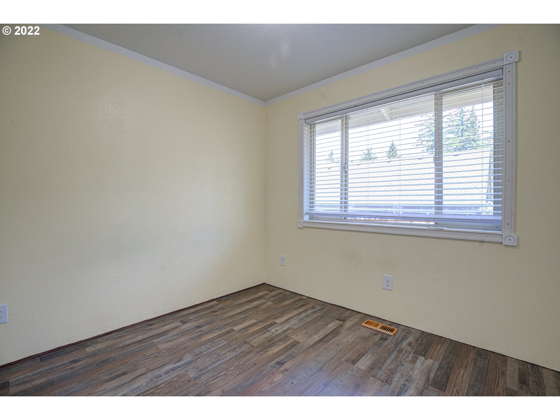 12355 Southeast Winston Road Damascus, OR 97089 - Photo 16 of 27 a view of an empty room with wooden floor and a window