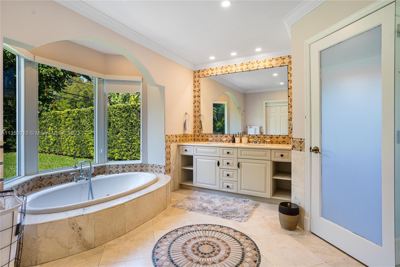 441 Miller Road Coral Gables, FL 33146 - Photo 19 of 34 a spacious bathroom with a tub sink and mirror