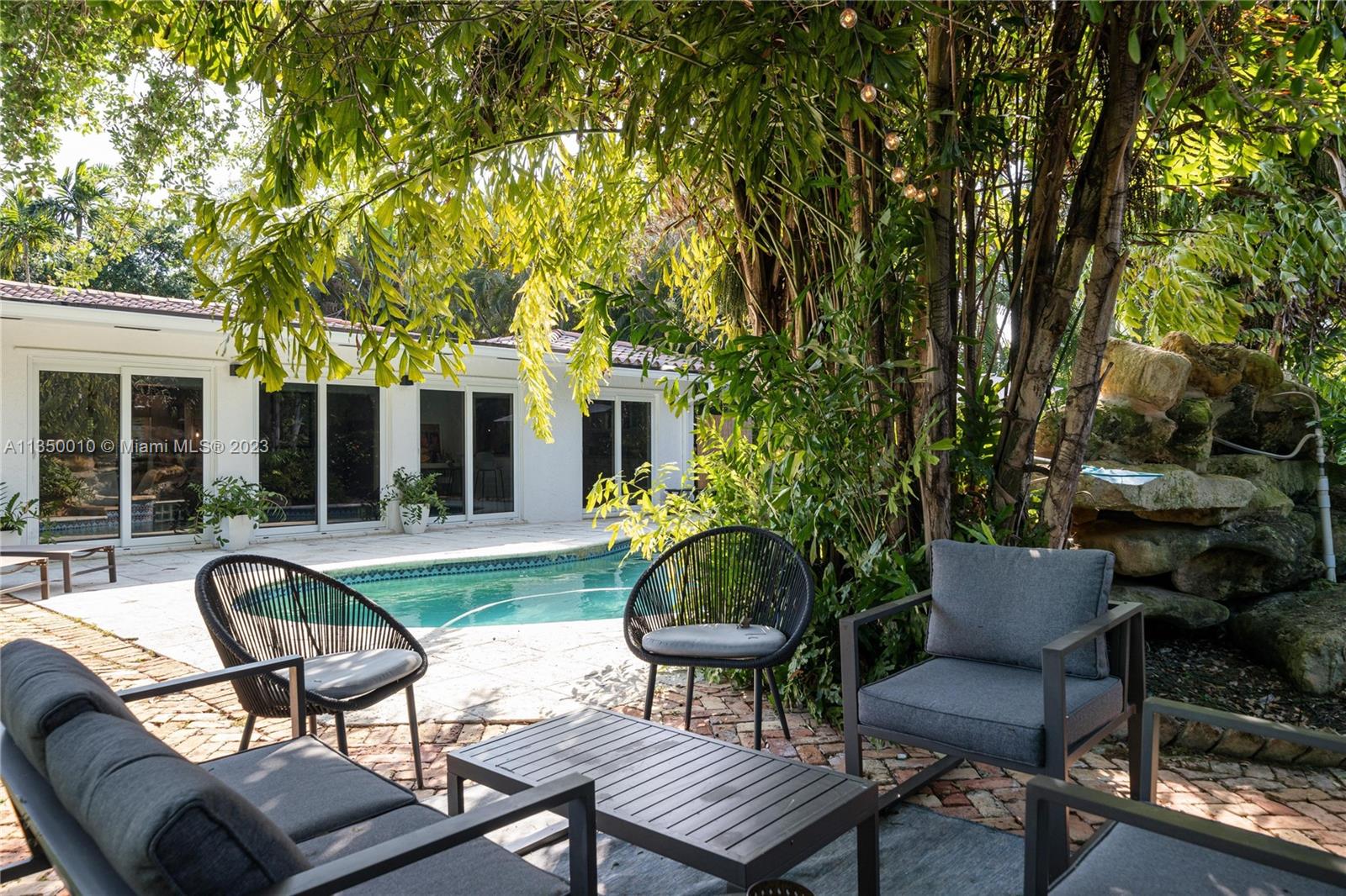 441 Miller Road Coral Gables, FL 33146 - Photo 28 of 34 a view of a patio with couches table and chairs and potted plants