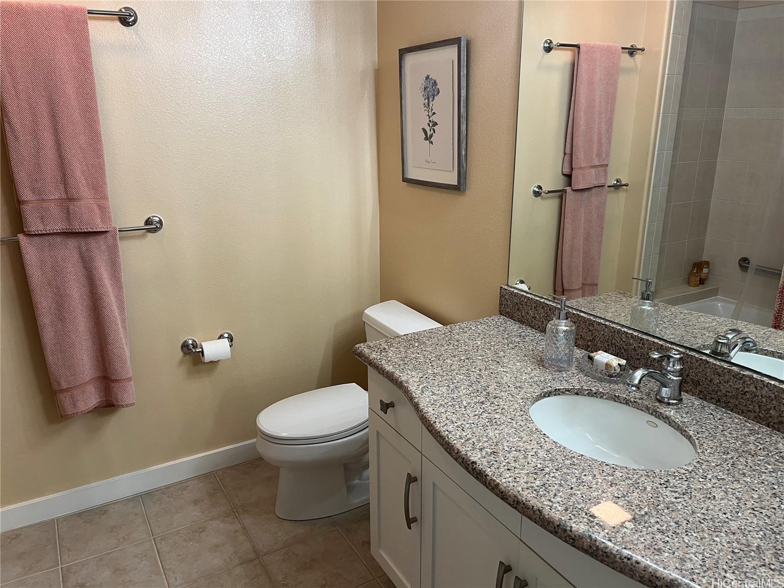 92-1001 Aliinui Drive, Unit 18C Kapolei, HI 96707 - Photo 12 of 14 a bathroom with a granite countertop sink toilet and a mirror