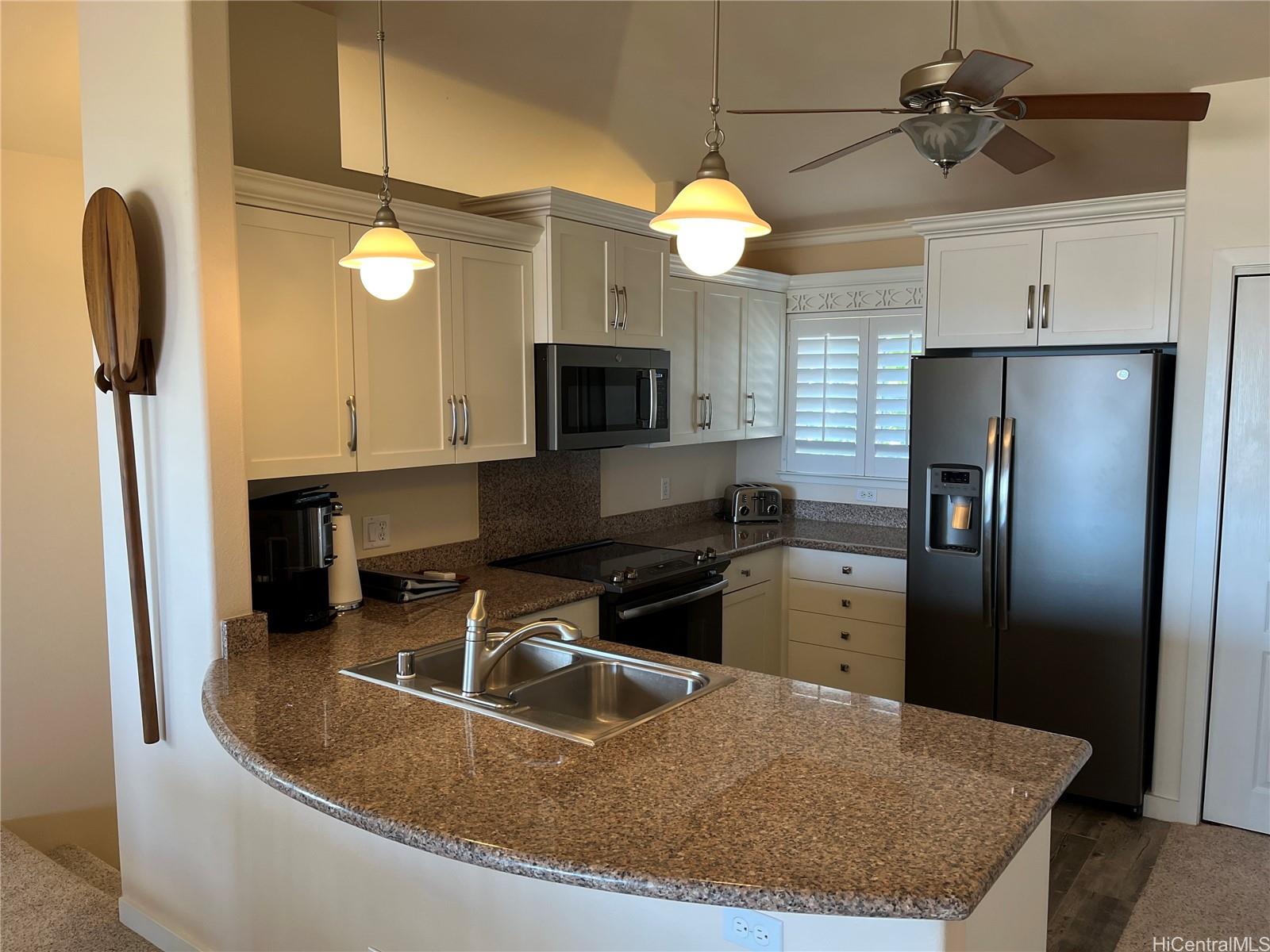 92-1001 Aliinui Drive, Unit 18C Kapolei, HI 96707 - Photo 7 of 14 a kitchen with a refrigerator a sink and a stove