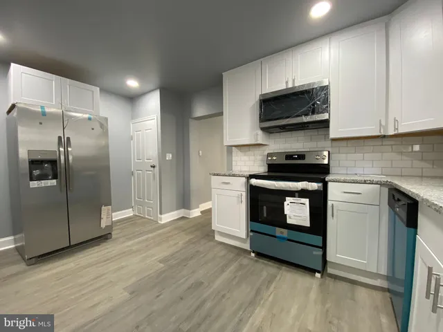 a kitchen with stainless steel appliances granite countertop a stove a refrigerator and a microwave