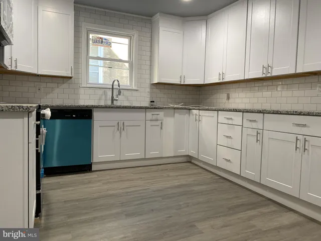 a kitchen with granite countertop cabinets stainless steel appliances and a window