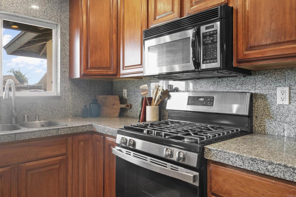 10036 3 Oaks Way Santee, CA 92071 - Photo 11 of 36 a kitchen with stainless steel appliances granite countertop a stove and a microwave