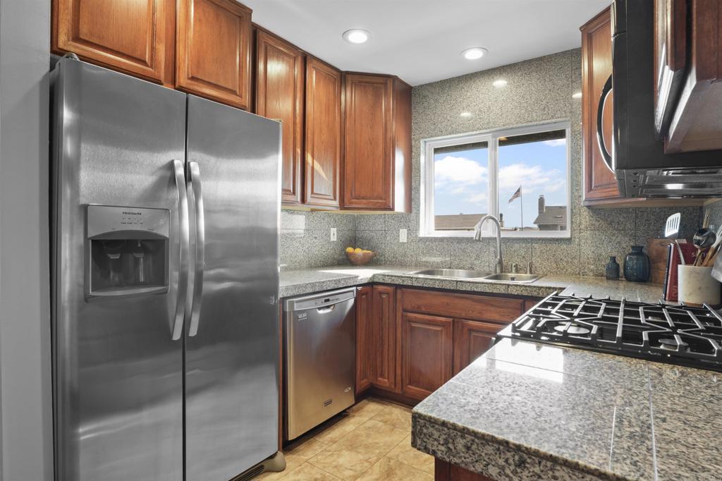 10036 3 Oaks Way Santee, CA 92071 - Photo 12 of 36 a kitchen with stainless steel appliances granite countertop a sink stove and refrigerator