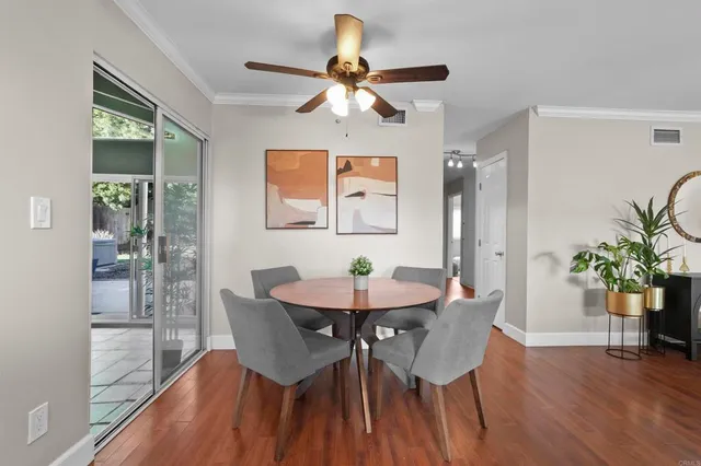a dining room with furniture potted plants and wooden floor