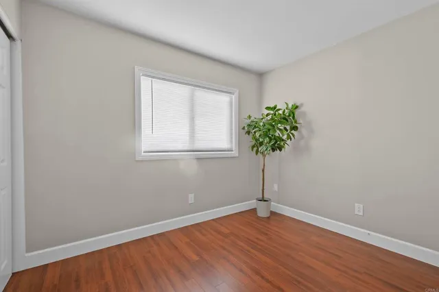 a view of a room with wooden floor and a potted plant