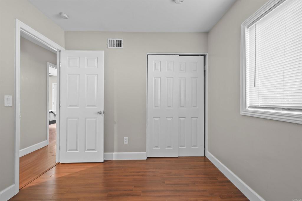 10036 3 Oaks Way Santee, CA 92071 - Photo 26 of 36 a view of an empty room with wooden floor and a window