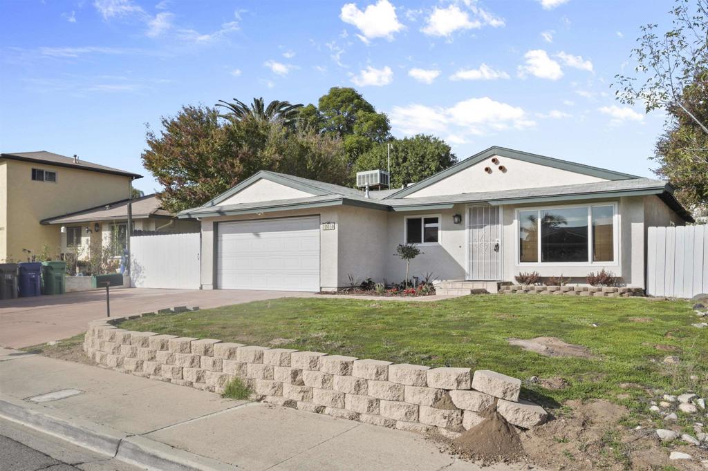 10036 3 Oaks Way Santee, CA 92071 - Photo 3 of 36 a front view of a house with a garden and yard