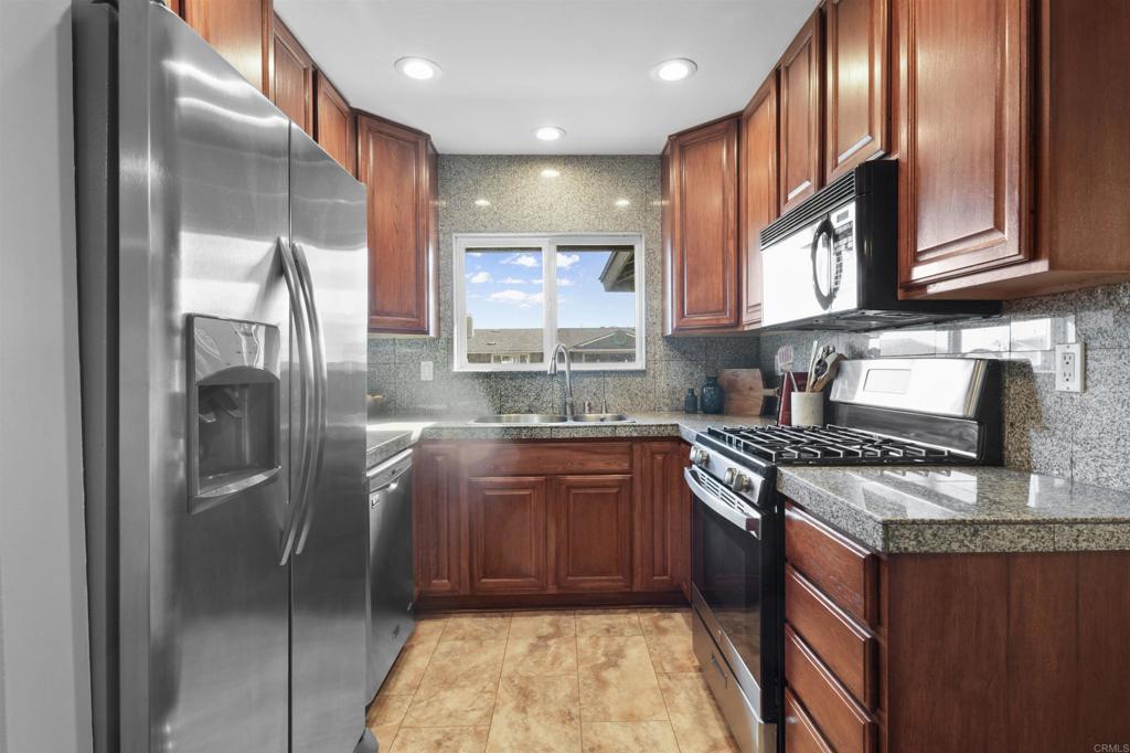 10036 3 Oaks Way Santee, CA 92071 - Photo 10 of 36 a kitchen with stainless steel appliances granite countertop a sink stove and refrigerator