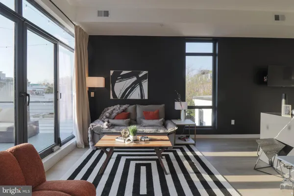 a living room with furniture fireplace and a large window