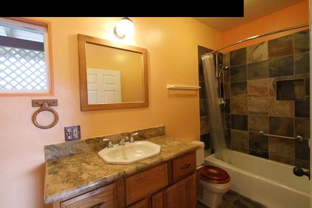 342 Kulike Road, Unit 1 Haiku, HI 96708 - Photo 17 of 30 a bathroom with a granite countertop sink toilet and shower