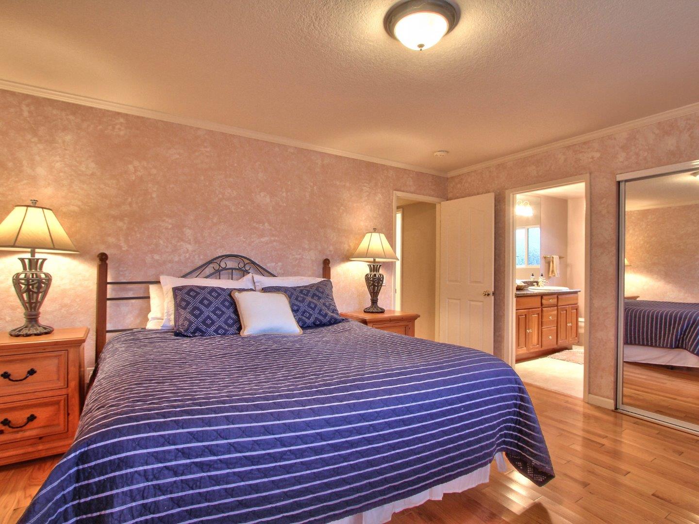 3076 Larkin Road Pebble Beach, CA 93953 - Photo 12 of 19 a bedroom with a large bed and a chandelier