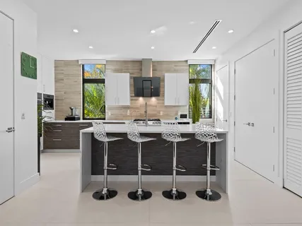 a kitchen with stainless steel appliances granite countertop a sink a stove and a refrigerator
