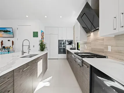 a kitchen with stainless steel appliances granite countertop a stove a sink and a refrigerator