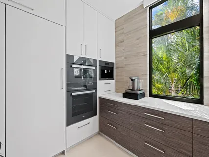a large white kitchen with a large window