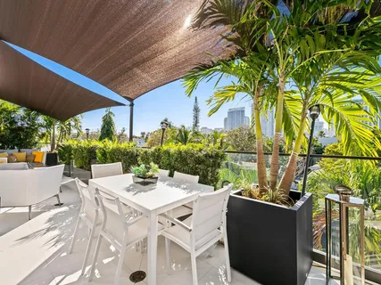 a bathroom with a sink a mirror and a potted plant