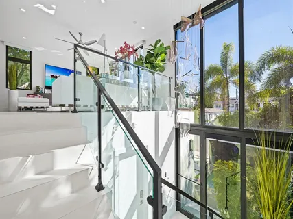 a living room with furniture floor to ceiling window and potted plant