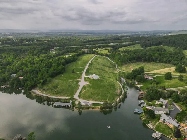an aerial view of a house with a yard and lake view