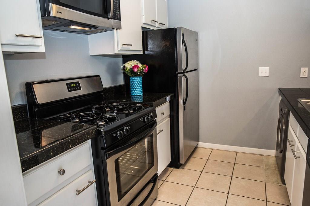 4209 Burnet Road, Unit 206 Austin, TX 78756 - Photo 6 of 20 A well-appointed kitchen showcasing dark granite counters and sleek stainless steel appliances.