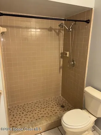 a bathroom with a toilet and a shower