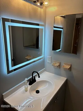 a bathroom with a sink a mirror and vanity