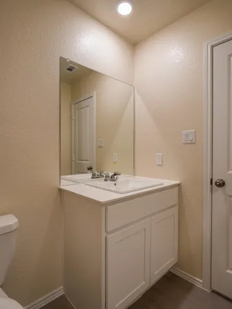 a bathroom with a sink and mirror with toilet