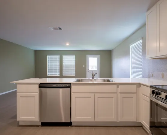 a kitchen with white cabinets and sink