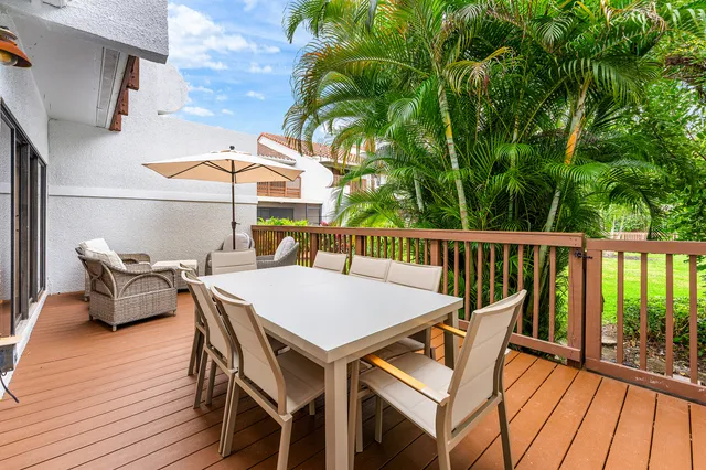 a view of a patio with table and chairs with wooden floor and fence